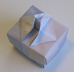 Handled box. Top view.

Made from 2 pieces of American Letter-sized paper.  This model uses "designer paper".   Design could be modified for A4 paper without too much difficulty.  The handle slot would be wider and the height a little lower. 

Designed and folded by Rosemary LYNDALL WEMM, June, 2005