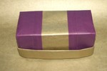 Hinged Lid Chest with torsion belt and a plain gold insert.  Purple and Gold Kraft paper.