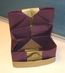 Here is the inside half of the hexagon.  The tips of the back flaps are inserted into the pockets.  This neatens the back flaps which can look scruffy if the folding is not extremely precise.   The strip can be continued until it tucks under the floor of the box.